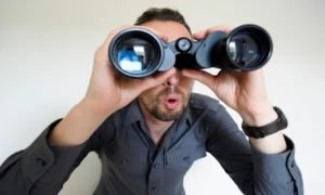 man-looking-through-binoculars-600x360